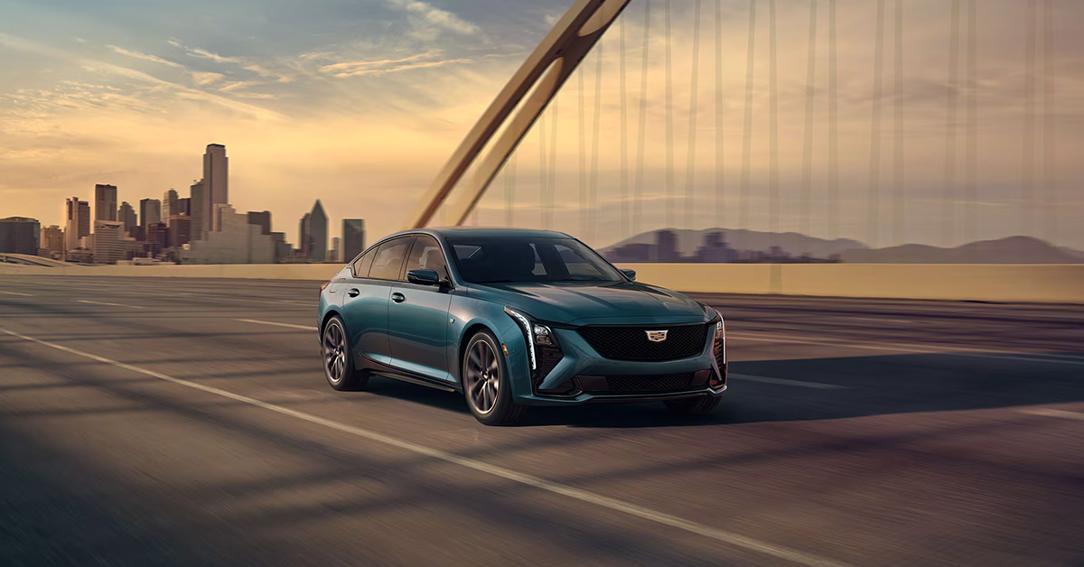 2025 Cadillac CT5 in Typhoon Metallic driving across a bridge