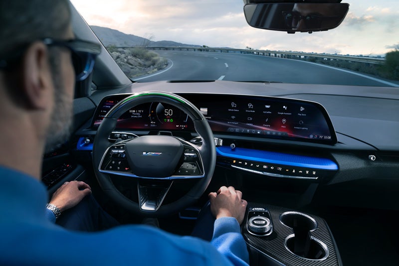 Front View of the 2026 OPTIQ-V Driving Through the Dusk Utilizing its Headlights | Crestview Cadillac of West Covina in West Covina CA
